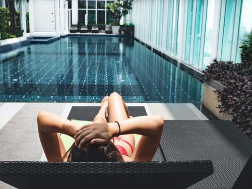 Person auf einer Liege an einem Hotel-Pool
