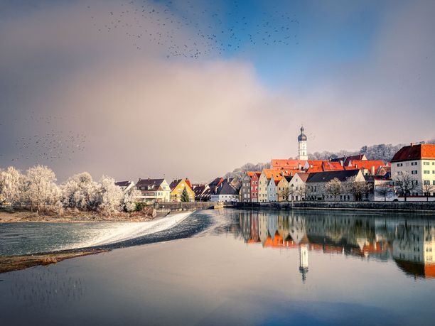 Kleine Stadt mit einem Kirchturm an einem See im Winter