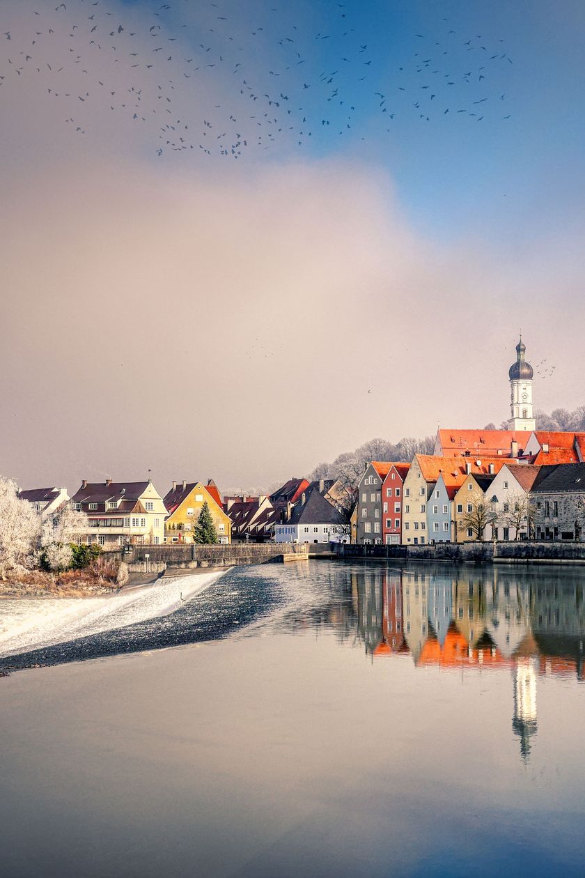Kleine Stadt mit einem Kirchturm an einem See im Winter