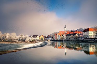 Kleine Stadt mit einem Kirchturm an einem See im Winter