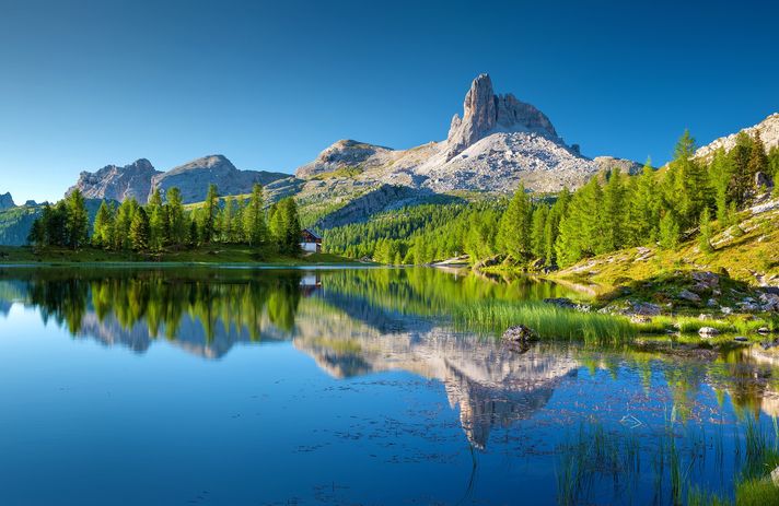 Landschaftsfoto mit einem See vor einem Bergpanorama und Wäldern