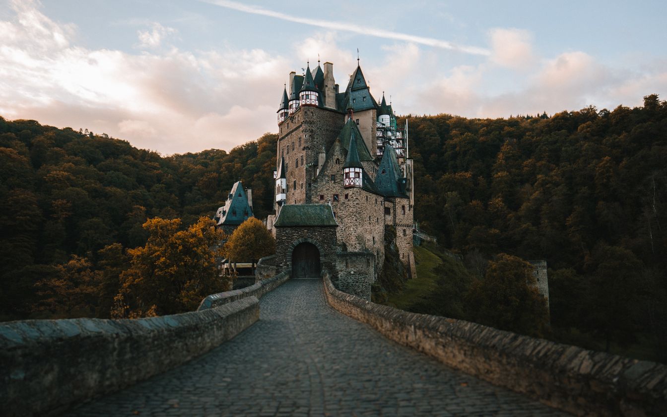 Schloss mit vielen Türmen, umgeben von dichtem Wald