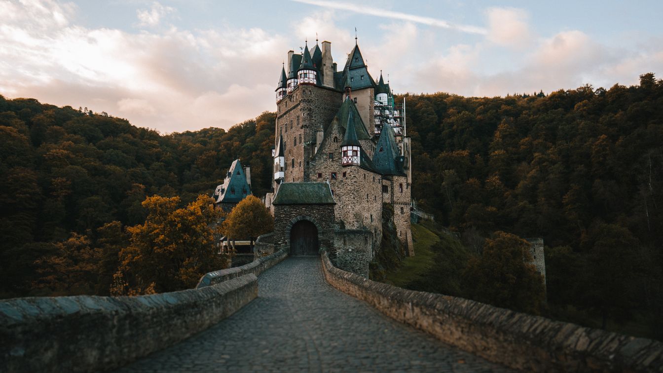 Schloss mit vielen Türmen, umgeben von dichtem Wald