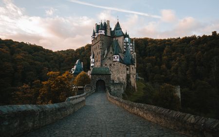 Schloss mit vielen Türmen, umgeben von dichtem Wald