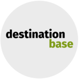 Rundes Logo von destination.base in schwarz-grüner Schrift