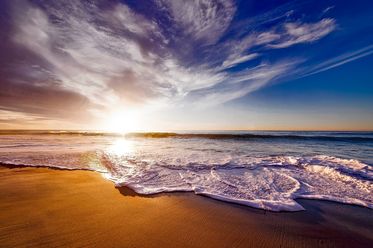 Flache Wellen an einem Strand bei Sonnenuntergang